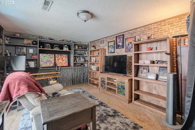 living room with carpet floors, a textured ceiling, brick wall, and visible vents