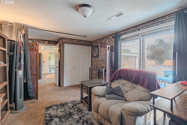 sitting room featuring visible vents, carpet flooring, a textured ceiling, and brick wall