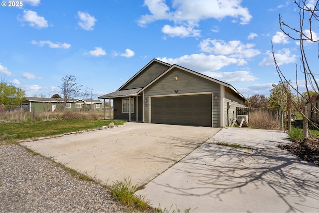 view of front of property with driveway, fence, and a garage