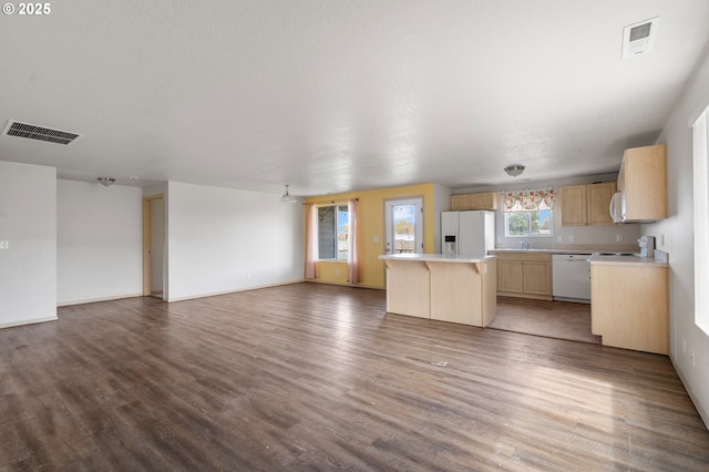 unfurnished living room featuring wood finished floors, baseboards, and visible vents