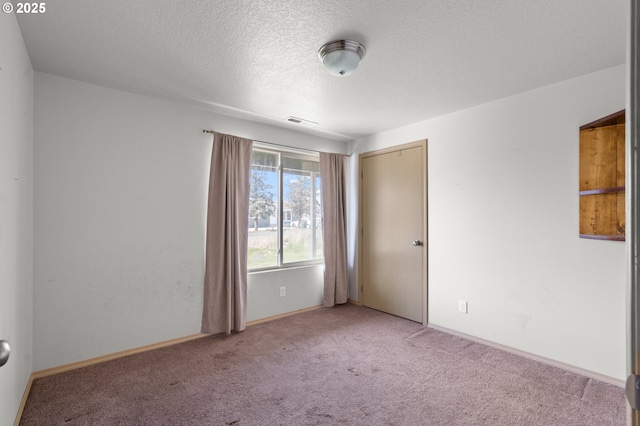 empty room featuring visible vents, a textured ceiling, baseboards, and carpet floors
