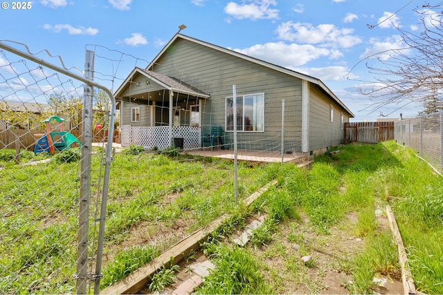 back of house with a fenced backyard and a sunroom