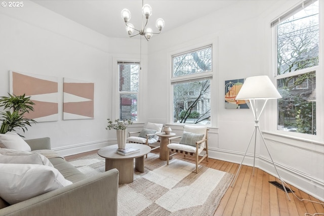 living area featuring hardwood / wood-style flooring and a chandelier