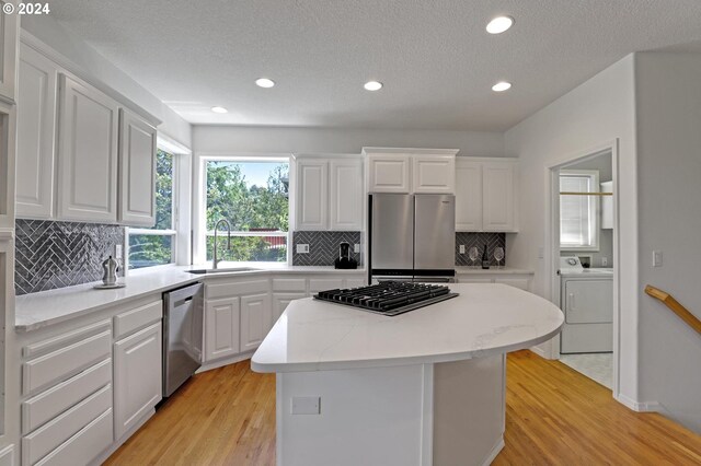 9719 NW Fleischner St, Portland, OR 97229 - kitchen with appliances with stainless steel finishes, a center island, a sink, light wood-style floors, and recessed lighting