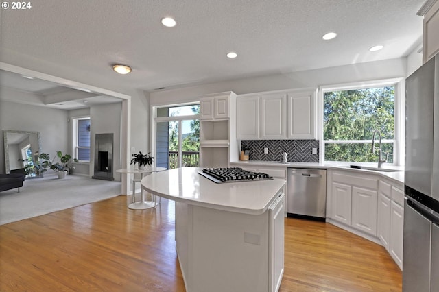 kitchen with white cabinetry, sink, a center island, and appliances with stainless steel finishes