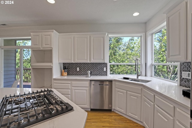 kitchen with stainless steel appliances, sink, and white cabinets