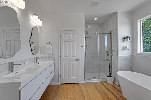 bathroom featuring vanity, hardwood / wood-style floors, shower with separate bathtub, and tile walls