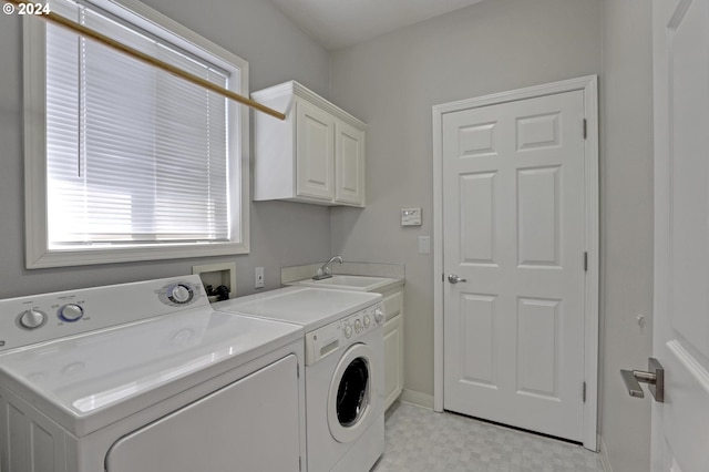 laundry room featuring cabinets, sink, and washer and clothes dryer