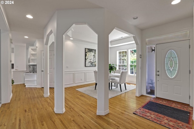 9719 NW Fleischner St, Portland, OR 97229 - foyer with light wood-type flooring, recessed lighting, wainscoting, arched walkways, and a decorative wall
