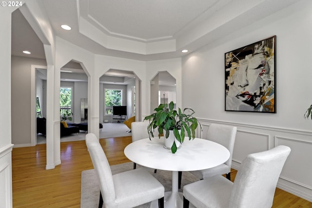 dining area featuring light hardwood / wood-style floors and a tray ceiling