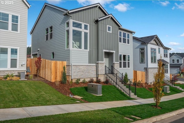 view of front facade featuring central AC and a front yard