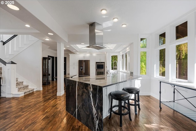 kitchen with stainless steel double oven, baseboards, island exhaust hood, dark wood-type flooring, and black fridge with ice dispenser