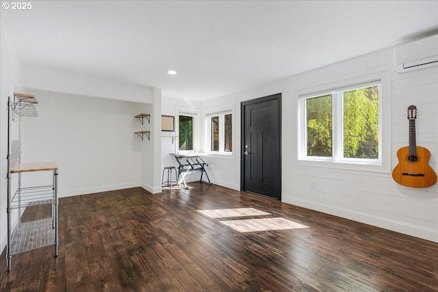 unfurnished living room featuring baseboards, a wall mounted air conditioner, recessed lighting, and hardwood / wood-style floors