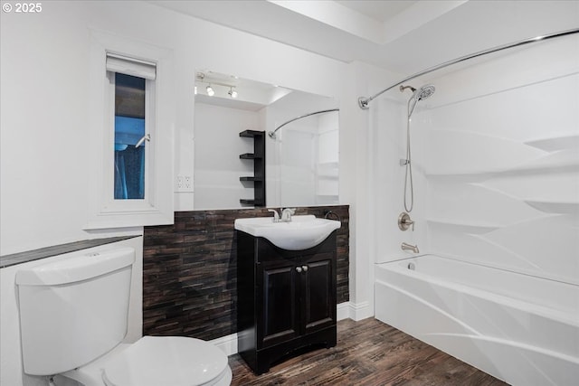 bathroom featuring vanity, shower / bathtub combination, toilet, and wood finished floors