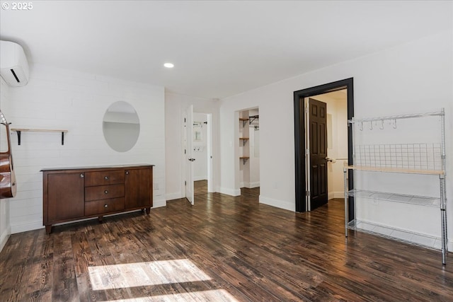 interior space with recessed lighting, a wall mounted air conditioner, baseboards, and wood finished floors
