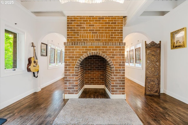 unfurnished living room with baseboards, ornamental molding, beamed ceiling, and dark wood-type flooring