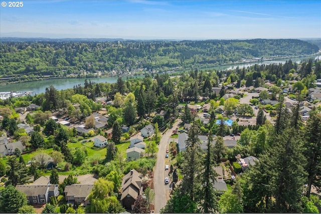 drone / aerial view featuring a water view, a view of trees, and a residential view