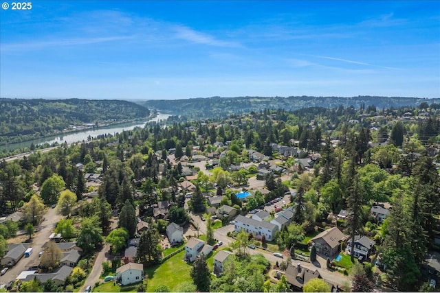 drone / aerial view with a water view, a residential view, and a wooded view