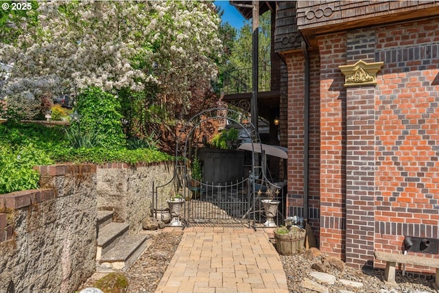 exterior space with brick siding and a gate