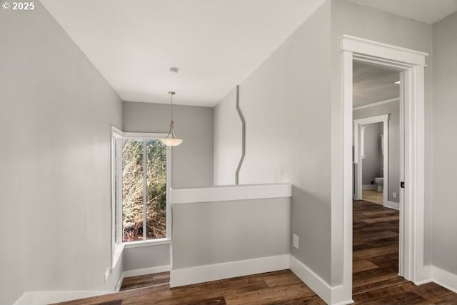 unfurnished dining area featuring a healthy amount of sunlight, baseboards, and dark wood-style flooring