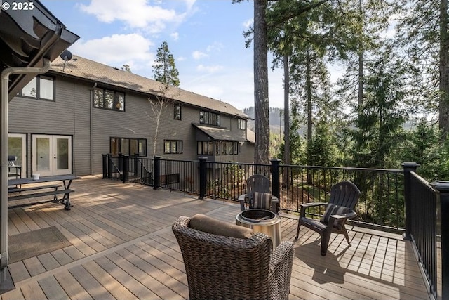 wooden deck featuring french doors and an outdoor fire pit