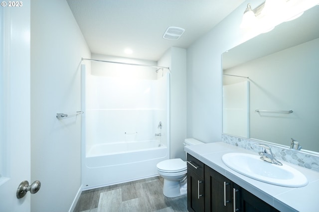 bathroom featuring  shower combination, vanity, toilet, and wood finished floors