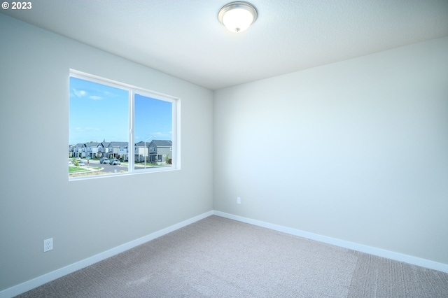 carpeted empty room with baseboards
