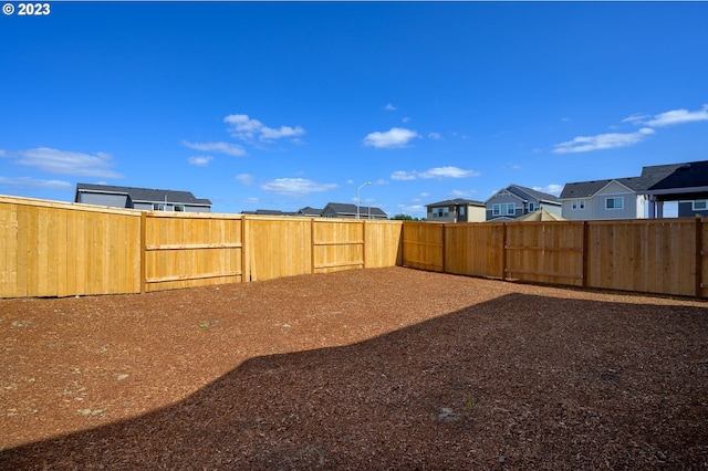 view of yard featuring a fenced backyard and a residential view