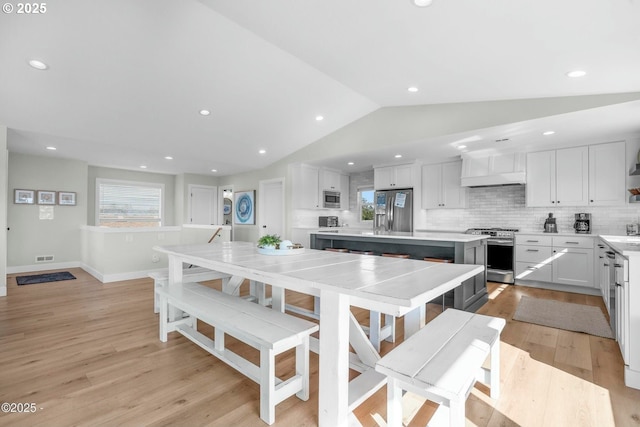 2150 NW Inlet Ave, Lincoln City, OR 97367 - kitchen with white cabinets, lofted ceiling, light wood-style flooring, and appliances with stainless steel finishes