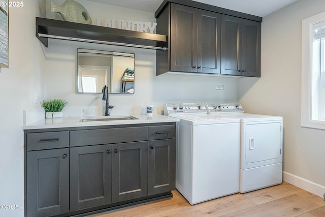 2150 NW Inlet Ave, Lincoln City, OR 97367 - laundry room with baseboards, a sink, light wood-style flooring, cabinet space, and washing machine and clothes dryer