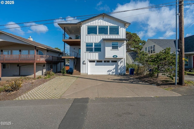 2150 NW Inlet Ave, Lincoln City, OR 97367 - view of front of home featuring board and batten siding, an attached garage, driveway, and a balcony