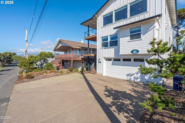2150 NW Inlet Ave, Lincoln City, OR 97367 - view of front of house featuring a balcony, driveway, board and batten siding, and an attached garage