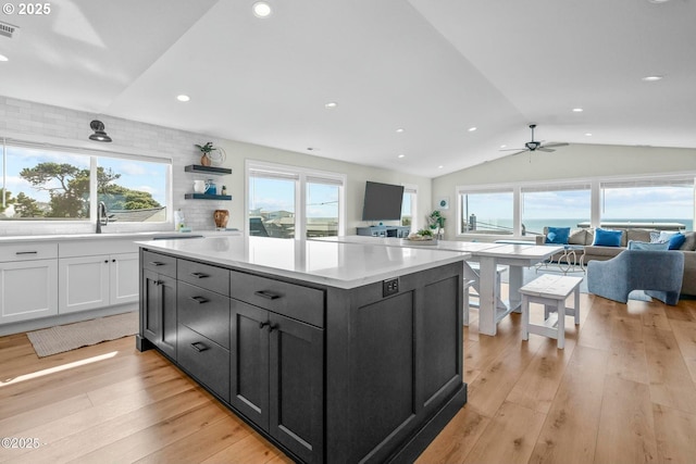 2150 NW Inlet Ave, Lincoln City, OR 97367 - kitchen featuring white cabinetry, visible vents, vaulted ceiling, light countertops, and open floor plan