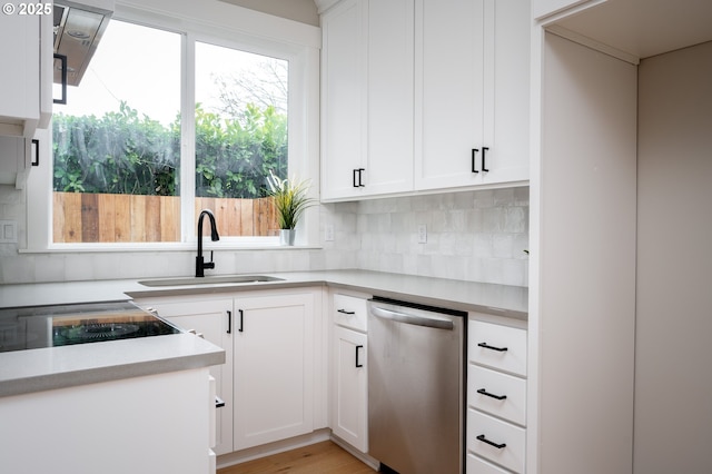 kitchen featuring tasteful backsplash, dishwasher, sink, white cabinets, and light hardwood / wood-style floors