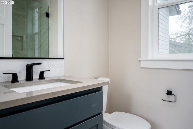 bathroom with vanity, an enclosed shower, and toilet