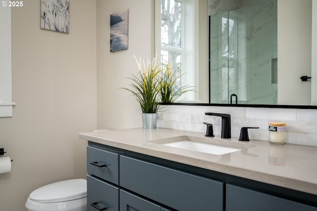 bathroom featuring vanity, toilet, and a shower with shower door