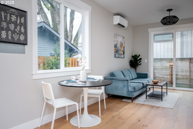 dining room with a wall unit AC and light wood-type flooring