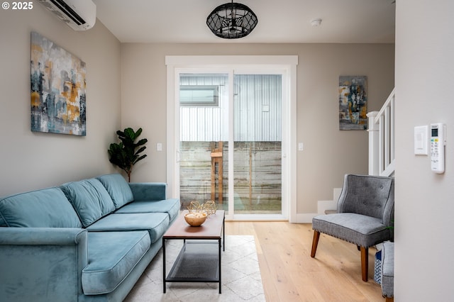 living room with light hardwood / wood-style flooring and a wall unit AC