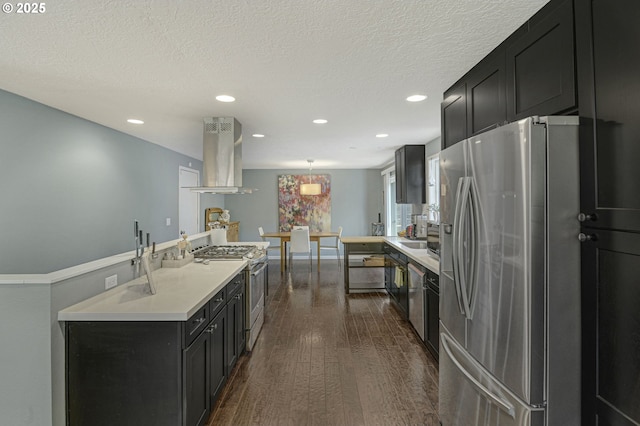 1842 SW Lobelia St, Portland, OR 97219 - kitchen featuring appliances with stainless steel finishes, island exhaust hood, recessed lighting, dark cabinetry, and light countertops