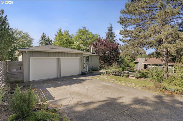 1842 SW Lobelia St, Portland, OR 97219 - view of front of property featuring a chimney, concrete driveway, an attached garage, and board and batten siding
