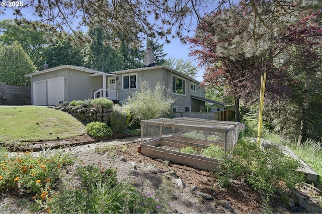1842 SW Lobelia St, Portland, OR 97219 - back of property featuring a vegetable garden, a chimney, and a garage