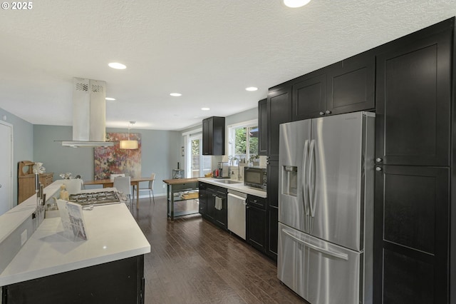 1842 SW Lobelia St, Portland, OR 97219 - kitchen with appliances with stainless steel finishes, island range hood, dark cabinetry, light countertops, and dark wood finished floors