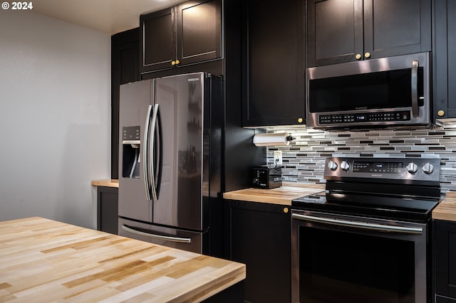 kitchen featuring backsplash, stainless steel appliances, and butcher block countertops