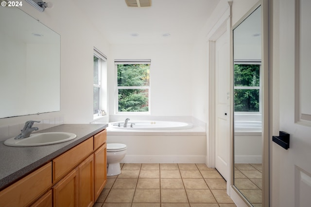 bathroom featuring tile patterned floors, a tub, vanity, and toilet