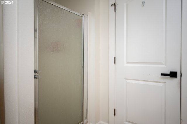 bathroom featuring a shower with door