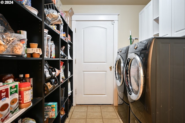 washroom with washing machine and dryer, light tile patterned flooring, and cabinets