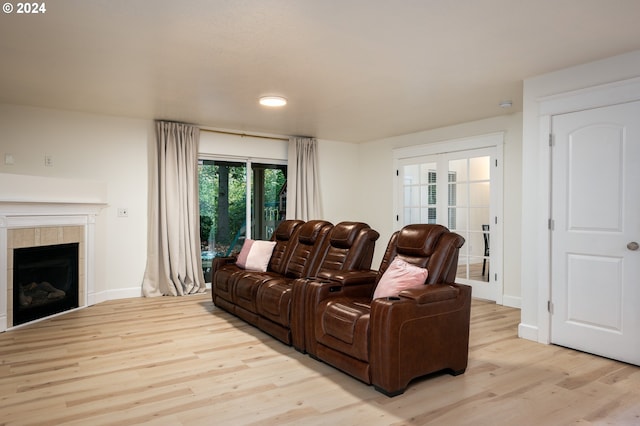 living room with light wood-type flooring and a tile fireplace