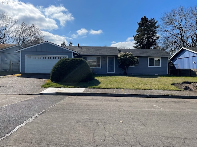 ranch-style home with a garage, aphalt driveway, board and batten siding, and a front yard