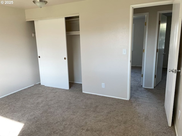 unfurnished bedroom featuring carpet, a closet, and baseboards