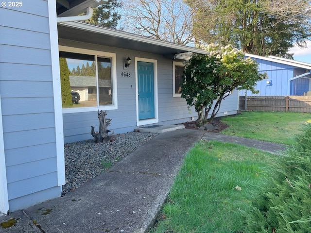 property entrance with a yard and fence